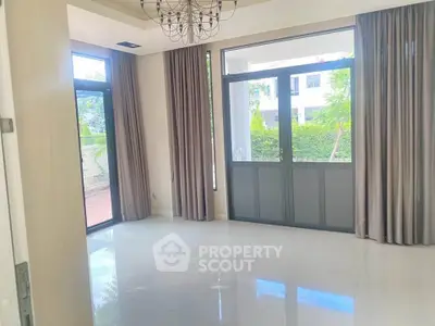 Spacious room with large windows and elegant curtains, perfect for natural light and garden views.