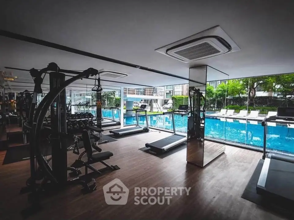 Luxurious gym with pool view in modern residential complex