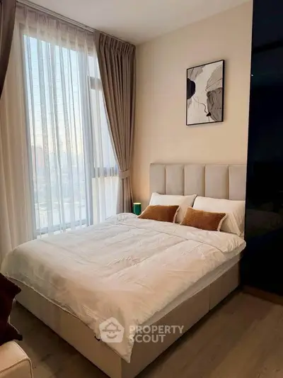 Cozy bedroom with modern decor and large window for natural light