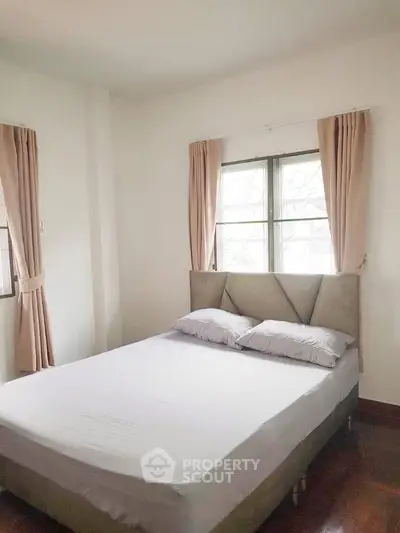 Cozy bedroom with natural light and elegant curtains