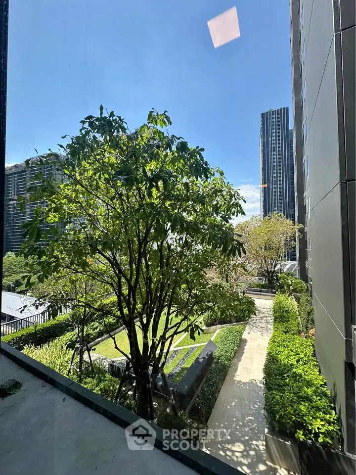 Stunning garden view from modern high-rise building, showcasing lush greenery and urban architecture.