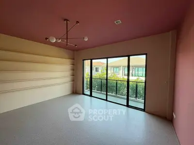 Spacious room with modern lighting and large windows overlooking a serene neighborhood.