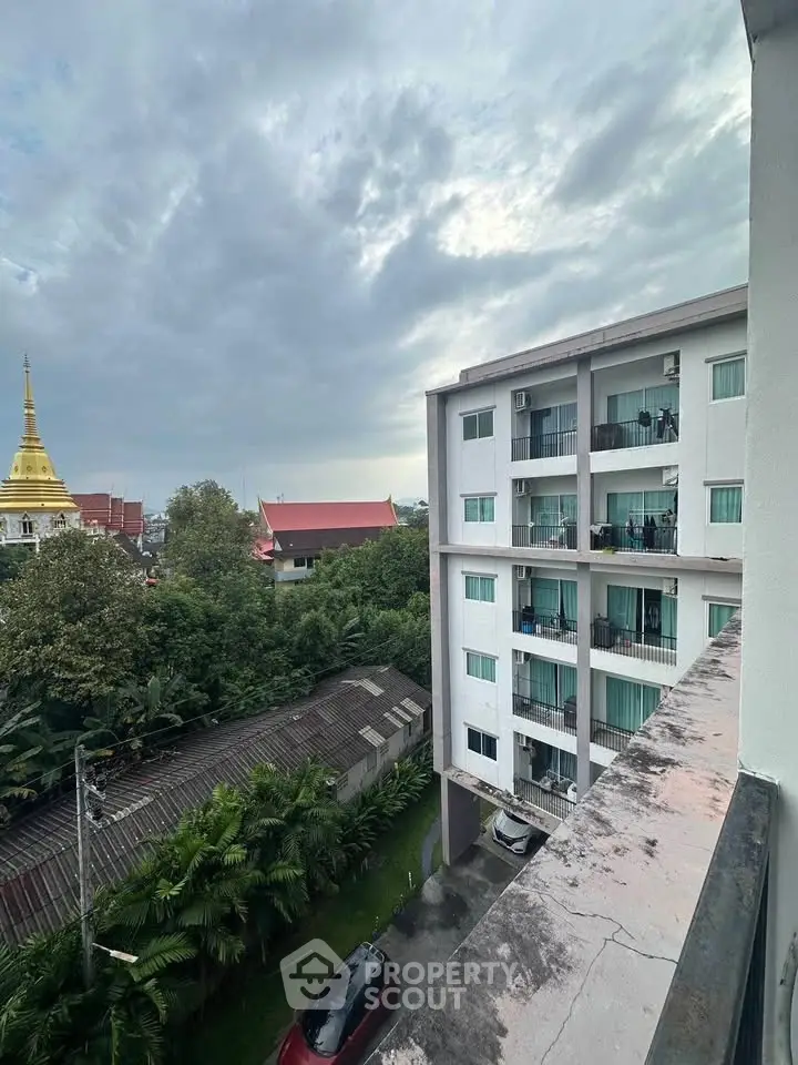 Stunning view of modern apartment building with lush greenery and cityscape.