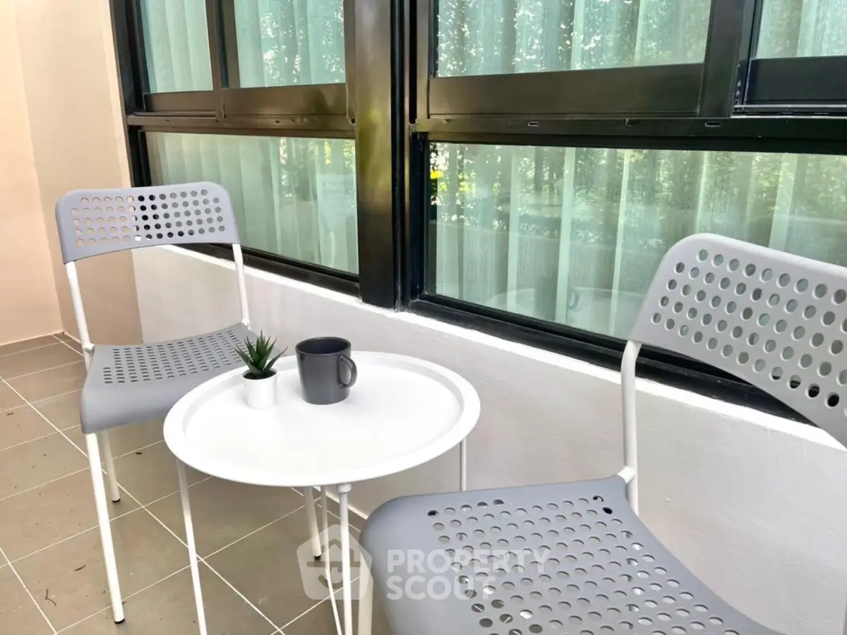 Charming balcony with modern chairs and table, perfect for relaxation.