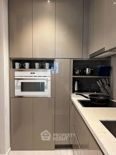 Modern kitchen with sleek cabinetry and built-in appliances, featuring a minimalist design and efficient layout.
