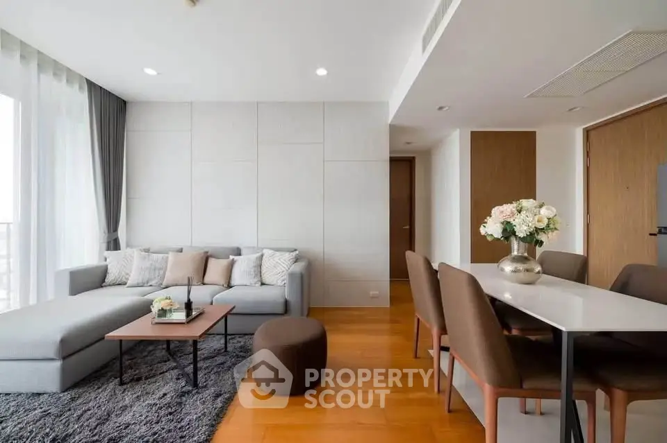 Modern living room with elegant decor and dining area, featuring a cozy sofa and stylish dining table.