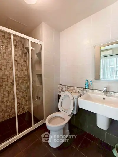 Modern bathroom with shower enclosure and sleek fixtures in a contemporary apartment.