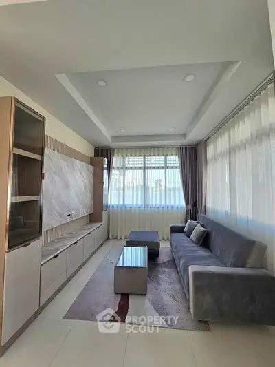 Modern living room with sleek furniture and large windows for natural light.