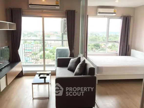 Modern studio apartment with large windows and scenic view, featuring a cozy living area and comfortable bed.