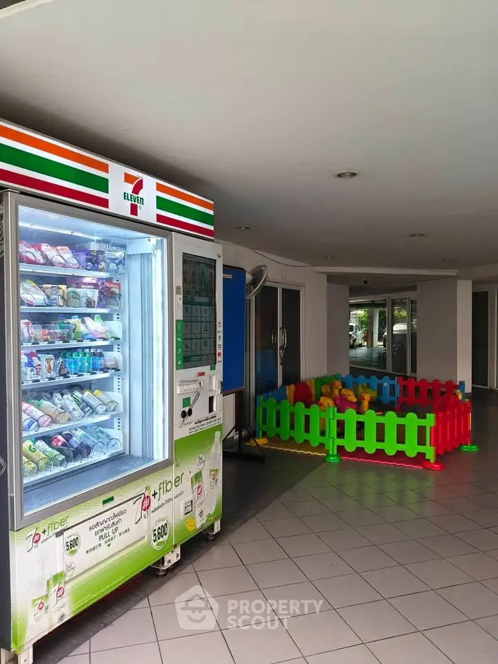 Spacious building entrance with vending machine and colorful play area, ideal for families.