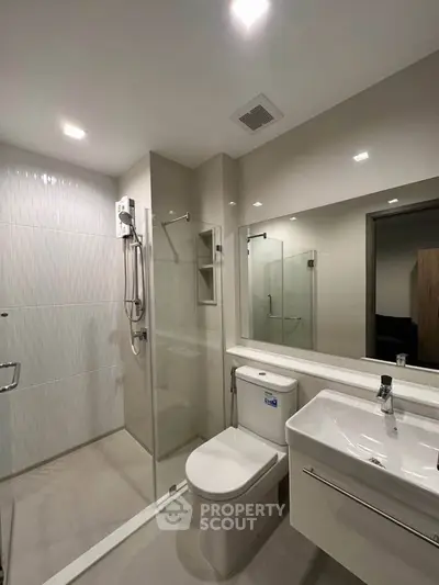 Modern bathroom with glass shower and sleek fixtures in a contemporary apartment.