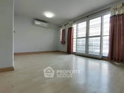 Spacious empty room with large windows and natural light