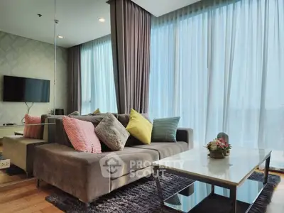 Stylish modern living room with cozy sofa and large windows offering ample natural light.