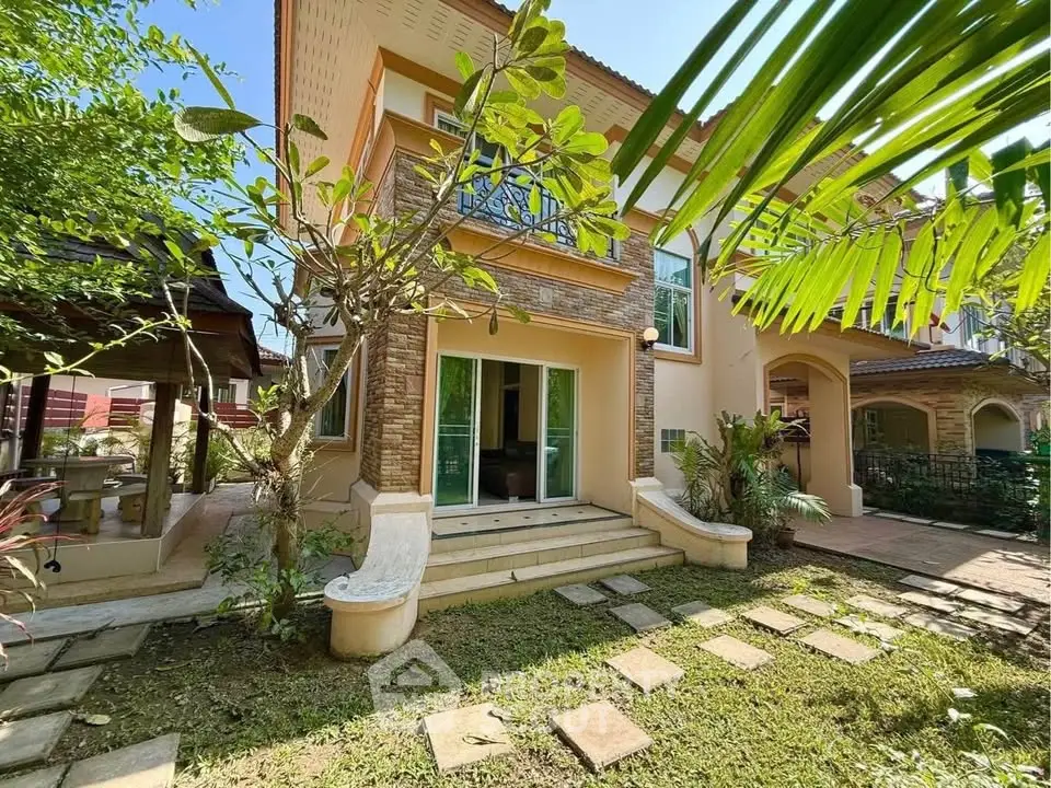 Charming two-story home with lush garden and inviting entrance, perfect for family living.