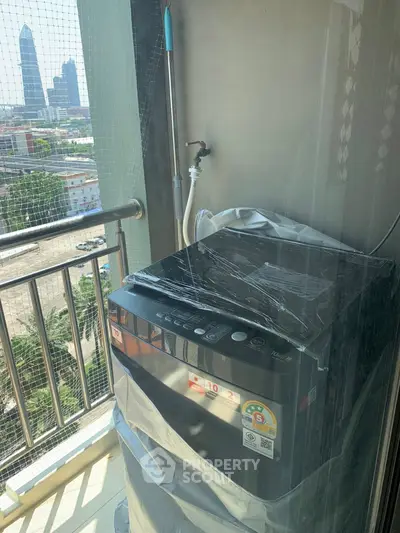 Modern washing machine on a balcony with city view, perfect for urban living convenience.