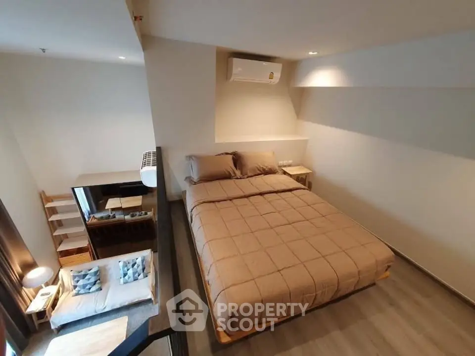Modern loft-style bedroom with cozy living area and stylish decor