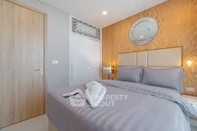 Luxurious bedroom with elegant decor and stylish bedding in modern apartment.