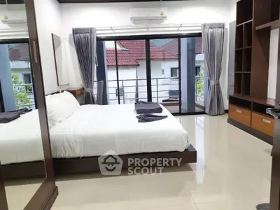 Spacious modern bedroom with balcony view and elegant furnishings