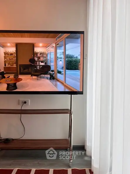 Modern living room with large TV and elegant decor, showcasing a cozy and stylish ambiance.