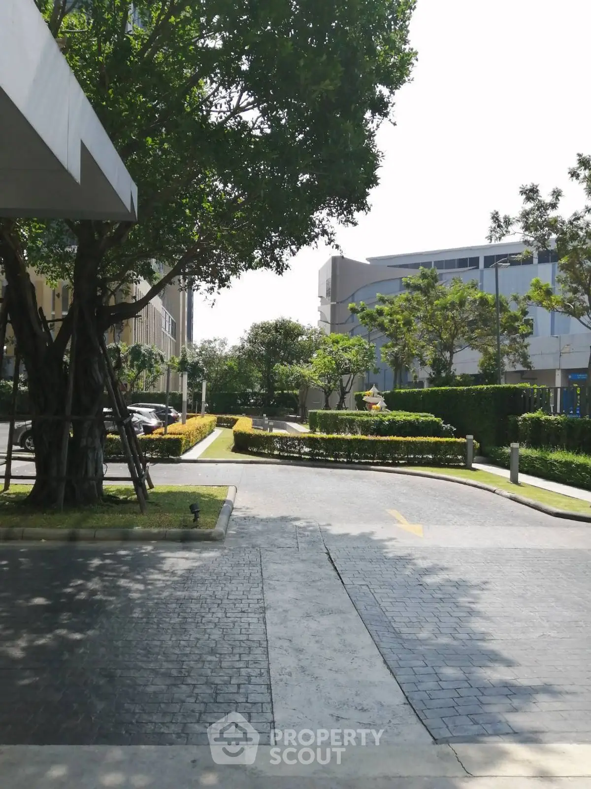 Beautifully landscaped entrance with lush greenery and modern architecture.