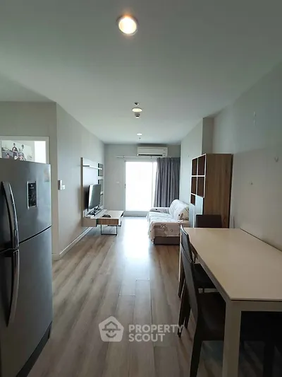 Modern living room with sleek furniture and natural light, featuring a cozy sofa and dining area.