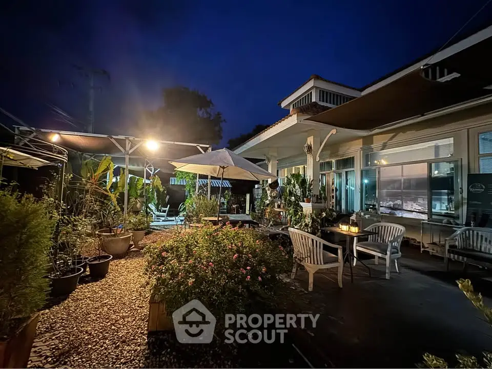 Charming evening garden patio with cozy seating and ambient lighting, perfect for outdoor relaxation.