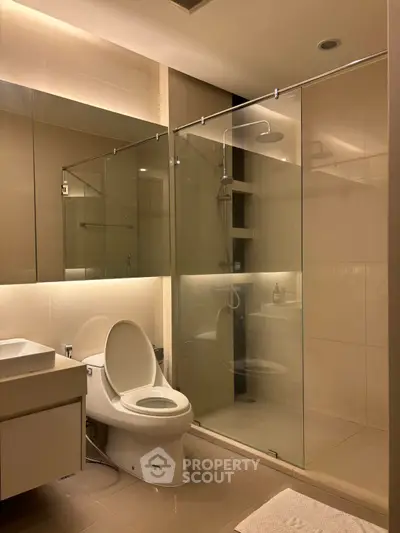 Modern bathroom with glass shower enclosure and sleek fixtures