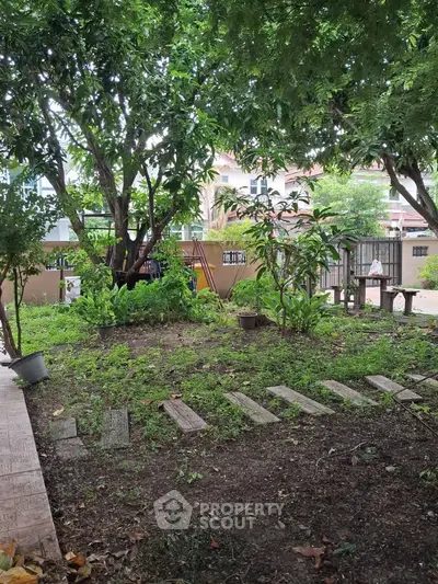Charming garden view with lush greenery and mature trees in a serene residential setting.