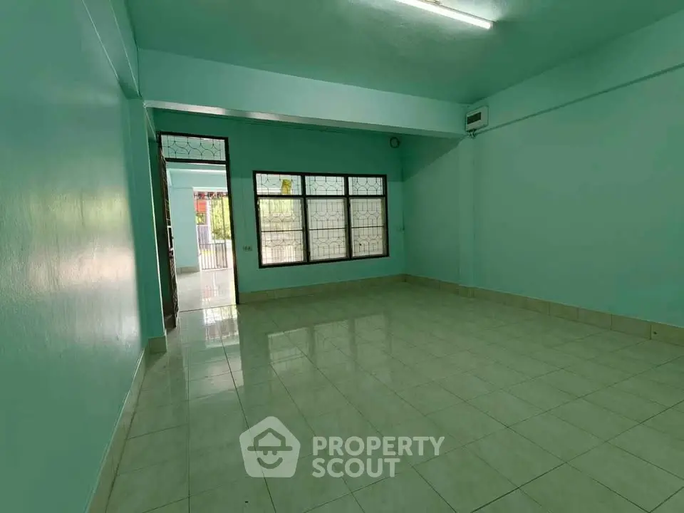 Spacious empty room with large windows and tiled floor, perfect for customization.