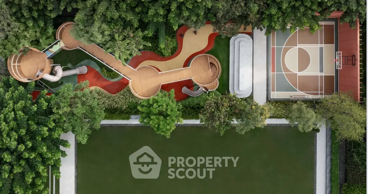 Aerial view of a modern playground and basketball court surrounded by lush greenery.