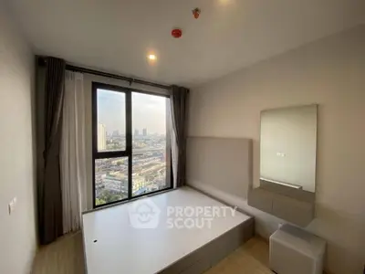 Modern bedroom with large window offering stunning city view, minimalistic design and natural light.