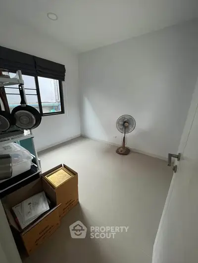 Minimalist room with fan and boxes, potential for customization