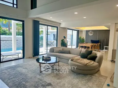 Luxurious open-plan living room with pool view and modern furnishings