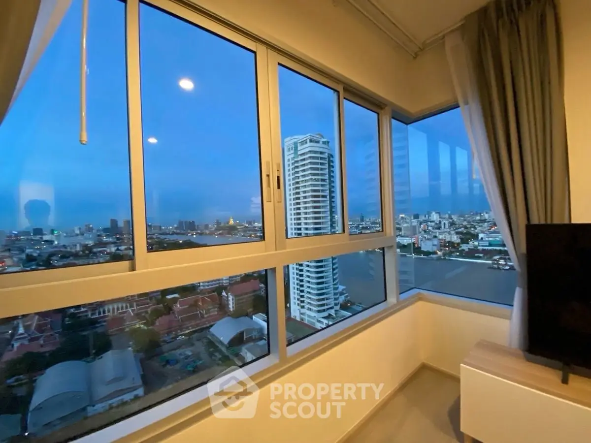 Stunning high-rise apartment with panoramic city and river views, featuring large windows and modern interior design.