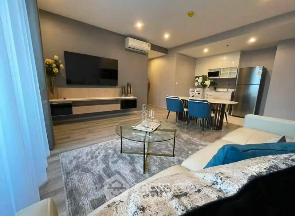 Modern living room with open kitchen, stylish decor, and cozy seating area in a contemporary apartment.