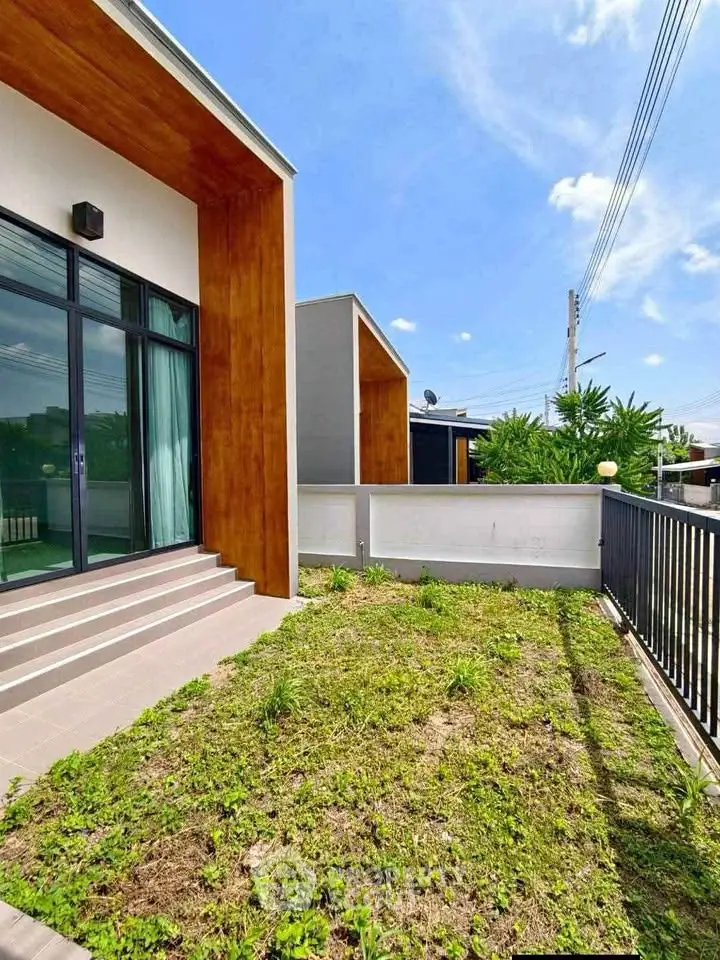 Modern home exterior with lush garden and sleek architectural design.