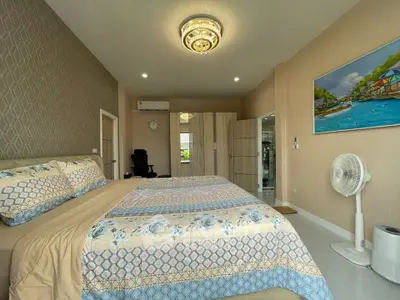 Spacious bedroom with elegant decor and modern furnishings, featuring a comfortable bed and stylish lighting.