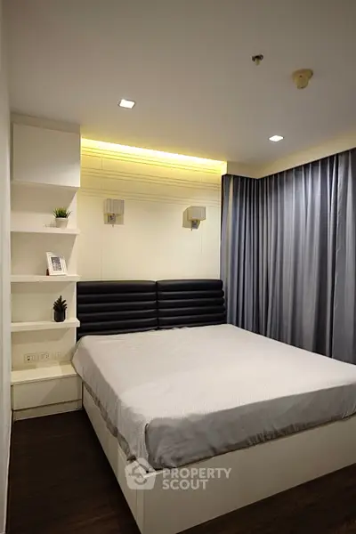 Modern bedroom with stylish lighting and elegant curtains in a contemporary apartment.