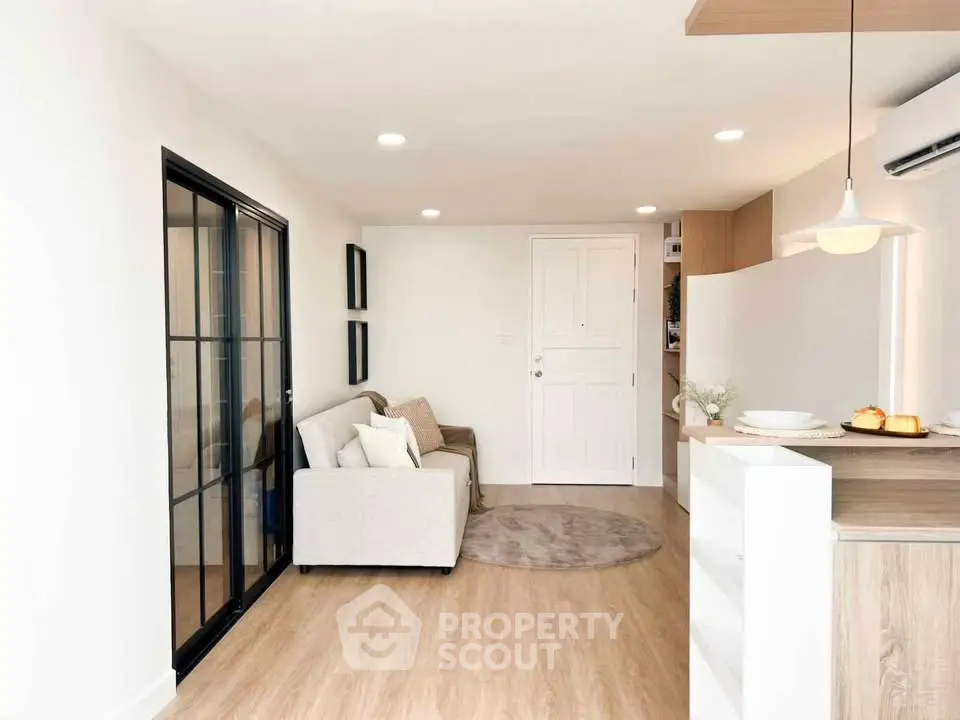Modern living room with cozy sofa and stylish kitchen in open layout apartment.