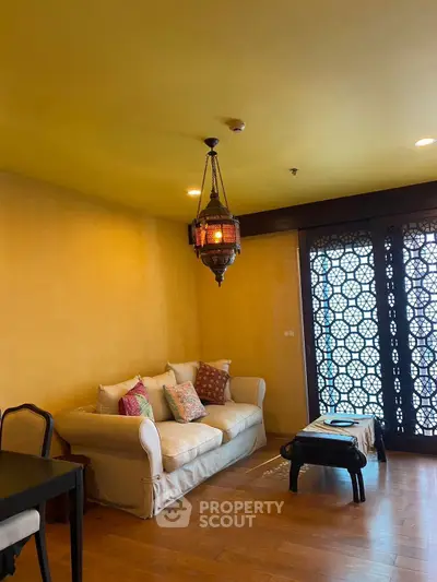 Charming living room with cozy sofa, vibrant pillows, and elegant lantern lighting.