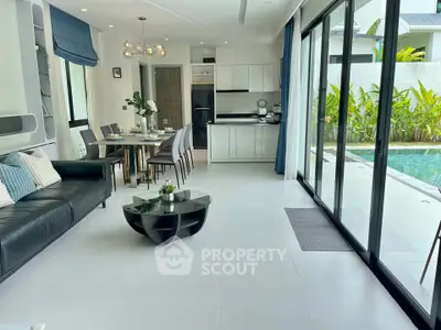 Modern open-plan living room with pool view and sleek kitchen design