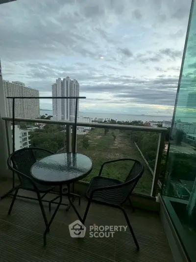 Stunning balcony view with outdoor seating overlooking cityscape and greenery, perfect for relaxation.