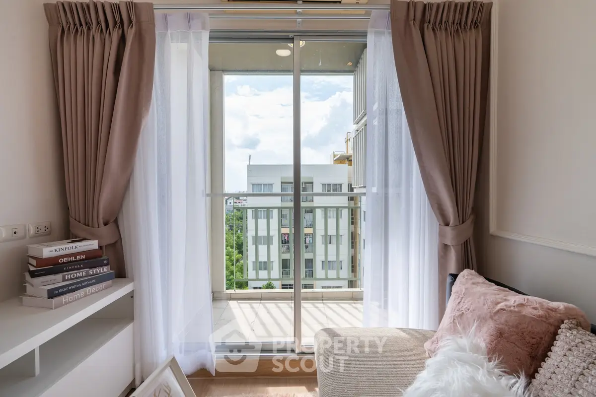 Cozy living room with balcony view, elegant curtains, and plush seating for ultimate relaxation.