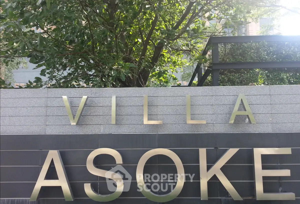 Villa Asoke entrance sign with lush greenery in the background, showcasing luxury real estate.