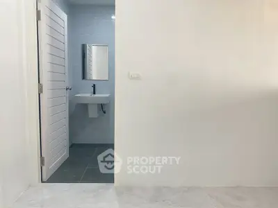Modern minimalist bathroom with sleek fixtures and white door
