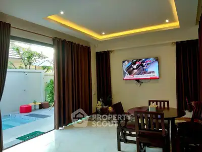 Luxurious living room with pool view, elegant dining set, and wall-mounted TV in modern home.