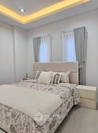 Elegant bedroom with modern decor and soft lighting, featuring a plush bed and stylish curtains.