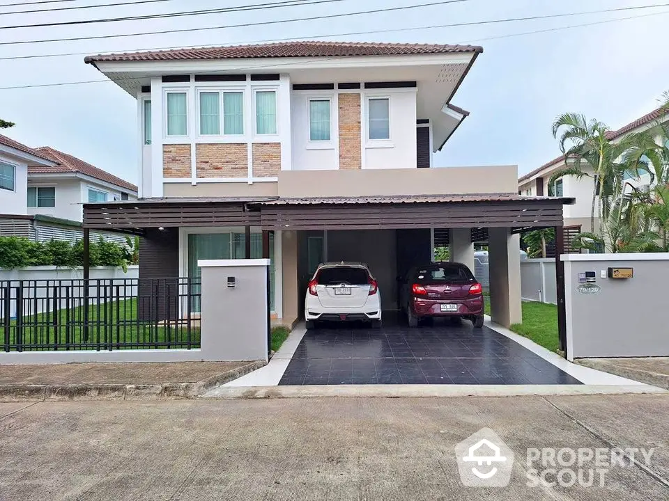 Modern two-story house with carport and landscaped front yard in suburban neighborhood.