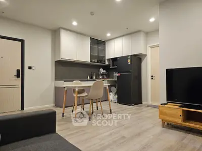 Modern open-layout kitchen and dining area with sleek appliances and cozy seating.