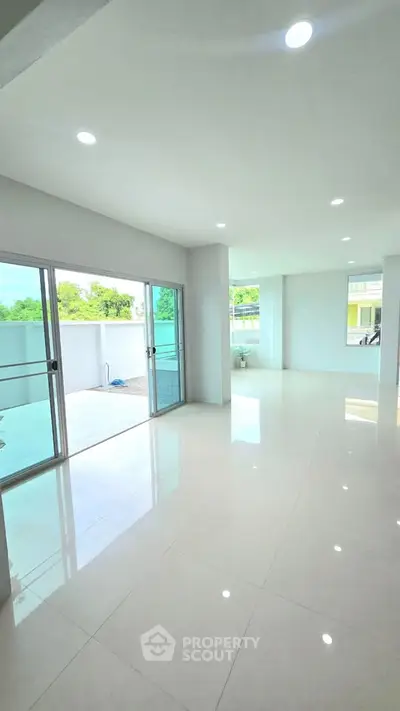 Spacious modern living room with large windows and balcony access